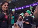 The image shows a man proposing to his partner at Melbourne Cricket Ground. The image shows a man proposing to his partner at Melbourne Cricket Ground.