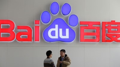 People talk in front of a Baidu's company logo at Baidu's headquarters in Beijing. (Reuters file)