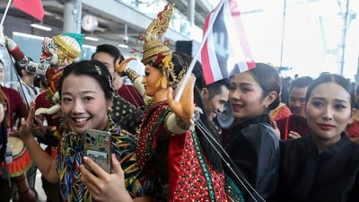 A Chinese tourist is welcomed by Thai traditional puppets during a welcome ceremony at Bangkok's International Airport. (REUTERS)