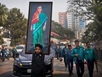 Bangladesh Elections 2024: A supporter of Bangladesh Awami League party carries a giant portrait of Bangladesh prime minister Sheikh Hasina during an election rally in Dhaka, Bangladesh.