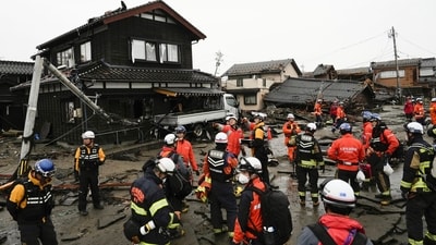 Firefighters and police search coastal area hit by earthquakes in Suzu, Ishikawa prefecture, Japan on Wednesday. Dozens are believed trapped under collapsed buildings. (AP) Firefighters and police search coastal area hit by earthquakes in Suzu, Ishikawa prefecture, Japan on Wednesday. Dozens are believed trapped under collapsed buildings. (AP)