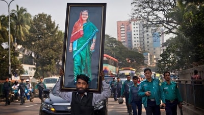 Bangladesh Elections 2024: A supporter of Bangladesh Awami League party carries a giant portrait of Bangladesh prime minister Sheikh Hasina during an election rally in Dhaka, Bangladesh. (AP) Bangladesh Elections 2024: A supporter of Bangladesh Awami League party carries a giant portrait of Bangladesh prime minister Sheikh Hasina during an election rally in Dhaka, Bangladesh. (AP)