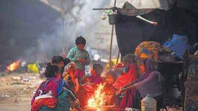 Gurugram, India-January 03: Homeless people sit around a bonfire to warm themselves on a cold winter morning under a flyover at National Highway-48, Rajiv Chowk, in Gurugram, India, on Wednesday, 03 January 2024. (Photo by Parveen Kumar/Hindustan Times) Gurugram, India-January 03: Homeless people sit around a bonfire to warm themselves on a cold winter morning under a flyover at National Highway-48, Rajiv Chowk, in Gurugram, India, on Wednesday, 03 January 2024. (Photo by Parveen Kumar/Hindustan Times)