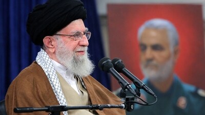 Iran's Supreme Leader Ayatollah Ali Khamenei on December 23, 2023 shows him addressing an audience from Kerman and Khuzestan in Tehran as behind him is displayed a picture of Qasem Soleimani. (AFP)