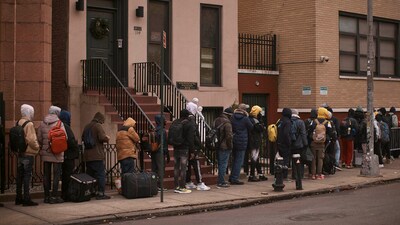 FILE - Migrants queue in the cold as they look for a shelter outside a migrant assistance center at St. Brigid Elementary School on Tuesday, Dec. 5, 2023, in New York. Nervous officials in suburbs and outlying cities near Chicago and New York are giving migrants arriving from the southern border a cold shoulder. Edison, New Jersey, the mayor warned he would send people back to the border if they came to his city in buses. The moves come amid attempts to circumvent new limits on dropping migrants in the two cities, opening a new front in response to efforts led by Texas Gov. Greg Abbott to pay for migrants to leave his state. (AP) FILE - Migrants queue in the cold as they look for a shelter outside a migrant assistance center at St. Brigid Elementary School on Tuesday, Dec. 5, 2023, in New York. Nervous officials in suburbs and outlying cities near Chicago and New York are giving migrants arriving from the southern border a cold shoulder. Edison, New Jersey, the mayor warned he would send people back to the border if they came to his city in buses. The moves come amid attempts to circumvent new limits on dropping migrants in the two cities, opening a new front in response to efforts led by Texas Gov. Greg Abbott to pay for migrants to leave his state. (AP)