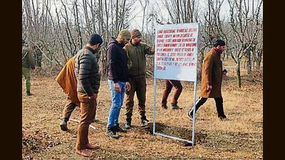 The police attach property of an accused in Ganderbal district on Wednesday. (HT photo)