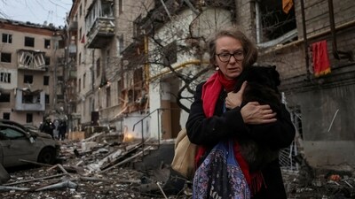 A local resident holding a cat leaves the site where residential buildings were heavily damaged during the Russian missile attack. (REUTERS)