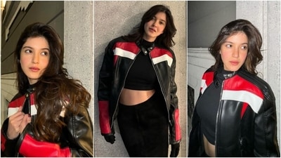In the second set of photos, Shanaya wore a black turtleneck top featuring full-length sleeves, a fitted silhouette, and a midriff-baring cropped hem. She styled the blouse with a leather biker jacket in black, red and white shades. High-waisted velvet bodycon midi skirt, gloves, centre-parted open wavy locks, a nude lip shade, and glowing blushed skin rounded it off. (Instagram) In the second set of photos, Shanaya wore a black turtleneck top featuring full-length sleeves, a fitted silhouette, and a midriff-baring cropped hem. She styled the blouse with a leather biker jacket in black, red and white shades. High-waisted velvet bodycon midi skirt, gloves, centre-parted open wavy locks, a nude lip shade, and glowing blushed skin rounded it off. (Instagram)