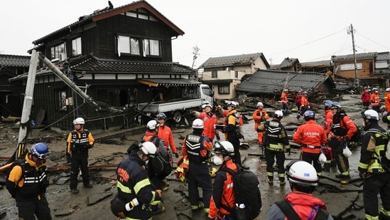 Firefighters and police search coastal area hit by earthquakes in Suzu, Ishikawa prefecture, Japan on Wednesday. Dozens are believed trapped under collapsed buildings.(AP)