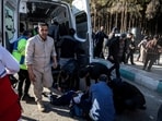 People gather near a body lying on the ground at the scene of explosions during a ceremony held to mark the death of late Iranian General Qassem Soleimani.