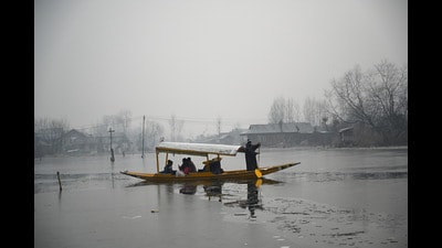 A man rows a boat on the partially frozen surface of the Dal Lake on a cold morning in Srinagar on Thursday. (Waseem Andrabi /HT)