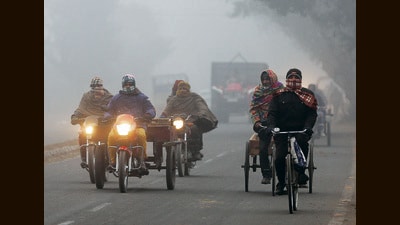 Commuters travel amid a cold and foggy weather in Amritsar on Thursday. (ANI)