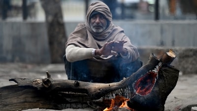A man sits around a bonfire on a cold winter morning. (HT Photo) A man sits around a bonfire on a cold winter morning. (HT Photo)