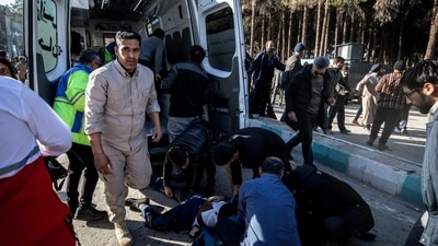 People gather near a body lying on the ground at the scene of explosions during a ceremony held to mark the death of late Iranian General Qassem Soleimani. (via REUTERS)