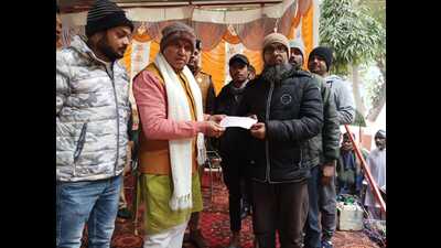 The minister giving a cheque of  ₹29,000 to Laik Ahmed, an inmate of Aligarh prison.Laik earned  ₹29,000 through his lock-making skill in three months. (HT)
