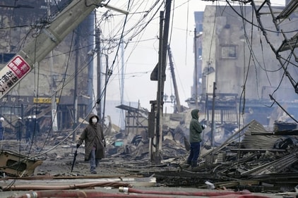 People walk through the damaged marketplace burned by fire after earthquake in Wajima, Ishikawa prefecture of Japan on January 2. (AP) People walk through the damaged marketplace burned by fire after earthquake in Wajima, Ishikawa prefecture of Japan on January 2. (AP)