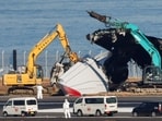 Officials try to remove the wreckage of a burnt Japan Airlines (JAL) Airbus A350 plane after a collision with a Japan Coast Guard aircraft at Haneda International Airport in Tokyo. (Reuters)