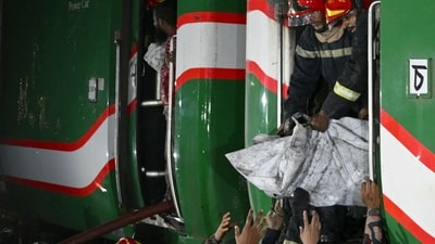Rescue personnel remove a body bag from a burnt-out carriage of the Benapole Express in Dhaka on January 5, 2024 (AFP)