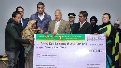 Chandigarh administrator Banwarilal Purohit handing over insurance cover cheques to the kin of a deceased employee. (HT Photo)