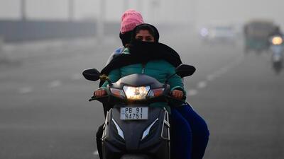Commuters making their way through a thick blanket of fog in Ludhiana. (Gurpreet Singh/HT)