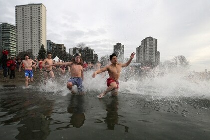 Participants run into the chilly waters of English Bay