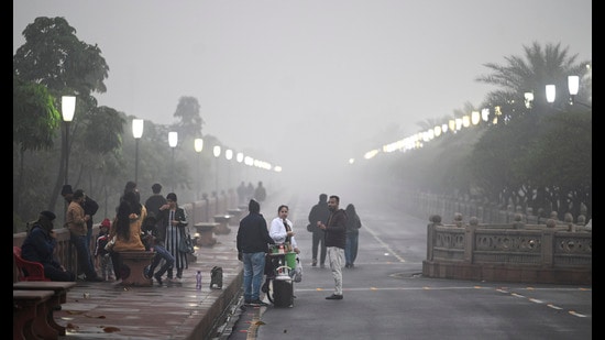 People out on a wet, cold and foggy evening at Marine Drive, in Lucknow, on Friday. (Deepak Gupta/HT)