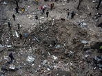 People stand next to a crater at a site of a Russian missile strike, amid Russia's attack on Ukraine.