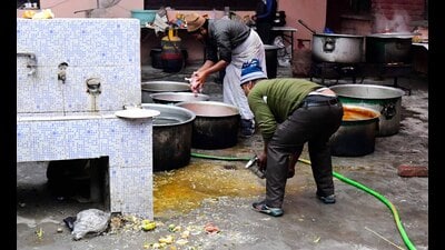 In one of the courtyards of Punjab Agricultural University (PAU) school, around five women were rolling chapatis on the rolling boards that were kept on the floor covered with newspapers. Not only that, but also people were seen walking right next to where rotis were being rolled. (Manish/HT)
