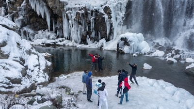 Tourists visit a partially frozen waterfall in Drang village, northwest of Srinagar. Kashmir has been going through a prolonged dry spell and a 79 per cent deficit in rainfall was recorded for December. (AP) Tourists visit a partially frozen waterfall in Drang village, northwest of Srinagar. Kashmir has been going through a prolonged dry spell and a 79 per cent deficit in rainfall was recorded for December. (AP)