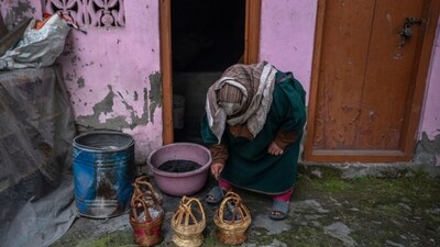 A Kashmiri woman fills a traditional firepot called ‘Kangri’ with charcoal in Srinagar, Kashmir, Friday, Jan. 5, 2024. Kangri is an age old device for keeping warm, consisting of a decoratively woven yellow wicker case housing an earthen pot for burning charcoal. (AP) A Kashmiri woman fills a traditional firepot called ‘Kangri’ with charcoal in Srinagar, Kashmir, Friday, Jan. 5, 2024. Kangri is an age old device for keeping warm, consisting of a decoratively woven yellow wicker case housing an earthen pot for burning charcoal. (AP)