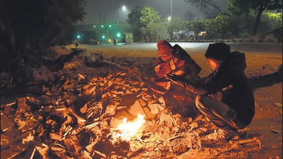 People sit around a bonfire in Khanpur on Saturday. (Sakib Ali/HT Photo) People sit around a bonfire in Khanpur on Saturday. (Sakib Ali/HT Photo)