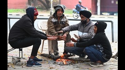 People warming up near a bonfire amid the cold weather in Sector 32, Chandigarh. (Keshav Singh/HT) People warming up near a bonfire amid the cold weather in Sector 32, Chandigarh. (Keshav Singh/HT)