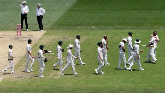 Australia's David Warner, second right, is hugged by teammate Marnus Labuschagne while Pakistan players arrive to congratulate Warner as he walks off the field after he lost his wicket on the fourth day of their cricket test match in Sydney, Saturday (AP)