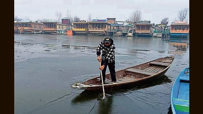 A man rows a boat over a partially frozen surface of the Dal Lake in Srinagar on Sunday. (Waseem Andrabi/HT) A man rows a boat over a partially frozen surface of the Dal Lake in Srinagar on Sunday. (Waseem Andrabi/HT)