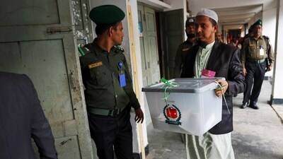 An official brings ballot box for counting casted votes after voting is timed out at a polling station, during the 12th general election in Dhaka, Bangladesh. (Reuters)