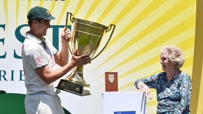 Daphne Surfleet (R), widow of late cricketing legend Richie Benaud, presents the trophy to Australia's captain Pat Cummins after the third cricket Test match between Australia and Pakistan (AFP)