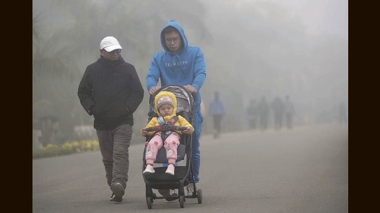 People taking a stroll amid the foggy weather at Sukhna Lake in Chandigarh on Sunday. (Keshav Singh/HT)