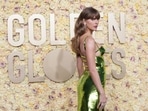 Taylor Swift poses on the 81st Golden Globe Awards red carpet in a Gucci gown. 