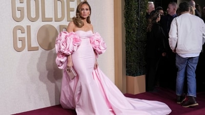 Jennifer Lopez's 2024 Golden Globes look showcases the perfect blend of grace and glamour as the gorgeous actress channels her inner Barbie in a pastel pink gown. Her dreamy gown features a sweetheart neckline, a body-hugging fit, oversized roses at the sides for a chic touch, and a sweeping train at the back. With pink diamond drop earrings, a pink crystal-embellished clutch, minimal make-up and retro hair, she definitely owed the red carpet. (Jordan Strauss/Invision/AP)