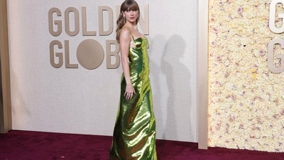 Taylor Swift, one of the world's most popular singers, dazzled on the red carpet at the Golden Globes in a shimmering green gown. The stylish diva gave off a Tinkerbell vibe as she donned a custom-made Gucci piece featuring a cupped bra, thin shoulder straps and an open back embellished with three thin straps. Swift accessorised the bold piece with a string of diamond jewellery. This included a pair of stacked cascading earrings, a large ear cuff, a dangling bracelet and several rings. She looked glamorous with minimal make-up and blow-dried bangs. (Jordan Strauss/Invision/AP)