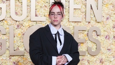 American pop star Billie Eilish never fails to turn heads with her incredible fashion sense. The Golden Globes were no exception, as the popular singer arrived in a boxy black blazer with a red cape, layered over a blue striped button-down shirt and a long, loose khaki skirt. She styled her look with red ruffled socks, Mary Jane heels, transparent glasses and a diamond stud. She completed her look with minimal make-up and her chic bun. (Jordan Strauss/Invision/AP)