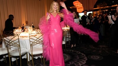 Hello Barbie! Margot Robbie, the Barbie movie superstar, walked the red carpet at the Golden Globes in a show-stopping outfit inspired by the iconic 1977 Superstar Barbie. Her stunning bright pink gown featured a plunging v-neckline, bodycon fit, thin straps and a shimmery fabric for a glamorous finish. She styled it with a matching net ruffled stole. With glossy lips, highlighted cheeks, black eyeliner and her blonde hair loose, she truly looked like a pink dream. (Chris Pizzello/Invision/AP)