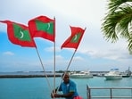 A worker carries national flags of Maldives in Male. 