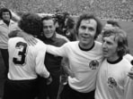 FILE - West German national soccer team captain Franz Beckenbauer, second from right, embraces his team mate, forward Juergen Grabowski while walking around the Olympic stadium