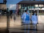 People wearing face masks as a precaution walk inside a hospital in Barcelona People wearing face masks as a precaution walk inside a hospital in Barcelona