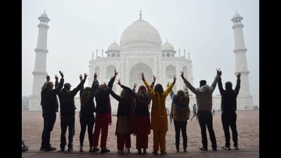 Tourists pose for photos at Taj Mahal on a cold and foggy winter day, in Agra on Tuesday. (PTI) Tourists pose for photos at Taj Mahal on a cold and foggy winter day, in Agra on Tuesday. (PTI)