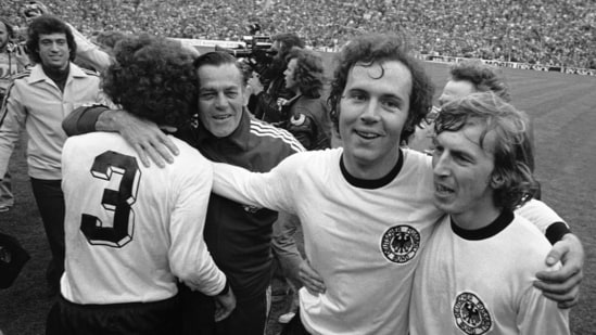 FILE - West German national soccer team captain Franz Beckenbauer, second from right, embraces his team mate, forward Juergen Grabowski while walking around the Olympic stadium (AP)