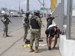 Soldiers check pedestrians for weapons at a check-point on a north-bound highway in Guayaquil, Ecuador, Wednesday, Jan. 10, 2024.