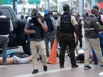 Ecuadorean police officers fuard the arrested suspects outside Ecuador's TC television channel after unidentified gunmen burst into the state-owned television studio live on air 