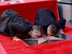 Mark Ruffalo and Willem Dafoe, who recently starred together in Poor Things, kiss Dafoe's newly unveiled star during the ceremony honoring him with a Hollywood Walk of Fame star in Hollywood.